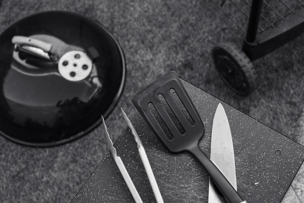 Barbecue accessories and cooking utensils arranged for outdoor grilling