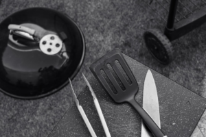 Barbecue accessories and cooking utensils arranged for outdoor grilling