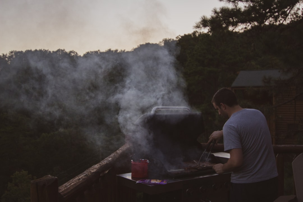 Outdoor cook wearing an apron while grilling barbecue