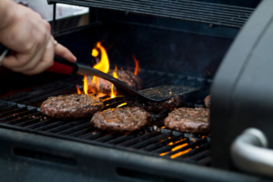 Barbecue grilling tools beside an outdoor grill