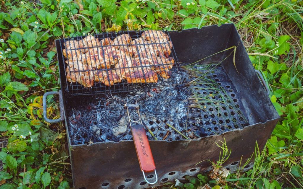 Food cooking in a wire grill basket over charcoal