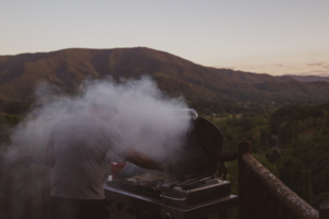 Backyard cook using a grill while comparing cooking space and grill size
