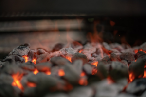 Smoldering charcoal coals for controlling smoker temperature