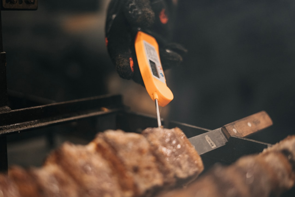 Barbecue grill cooking meat during a wireless thermometer guide